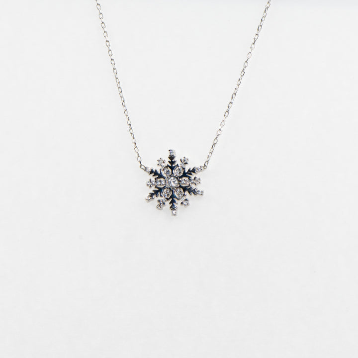 Dieses elegante 925 Silber Collier mit Anhänger ist mit einem funkelnden Schneeflocken-Motiv verziert, das mit strahlenden Zirkonia-Steinen besetzt ist. 