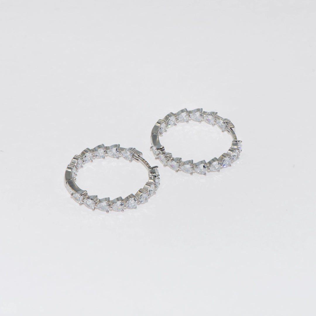 Creolen aus 925er Sterlingsilber. Die äußeren und inneren Teile des Ohrrings sind in Form eines Herzens mit Zirkonsteinen gestaltet und er ist als sehr stilvolles und elegantes Modell konzipiert. Eine perfekte Geschenkidee zum Valentinstag. Zeigen Sie auch Ihre Liebe mit diesen Ohrringen aus liebevollen Miniherzen zum Muttertag